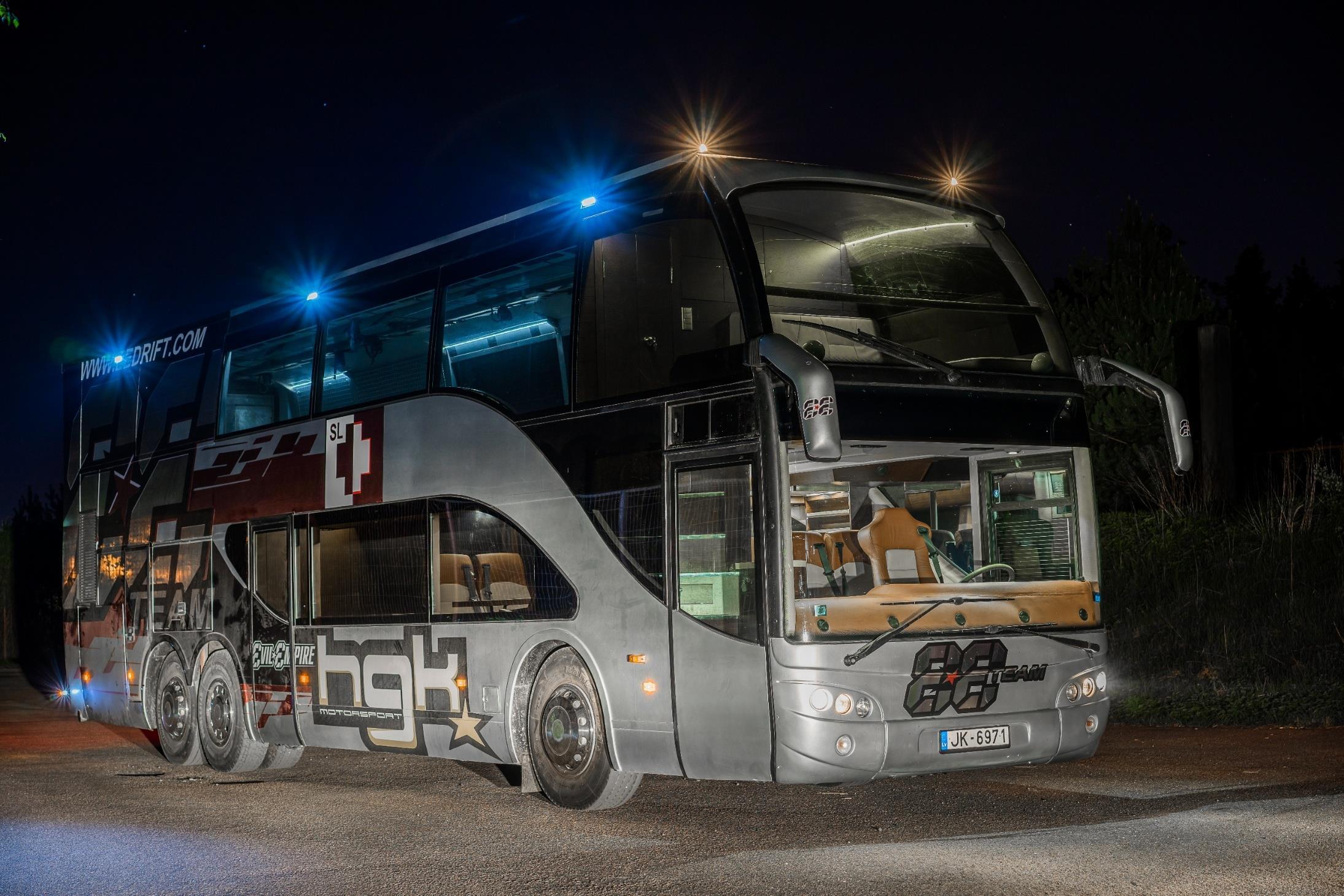 HGK Motorsport double-decker team bus at night