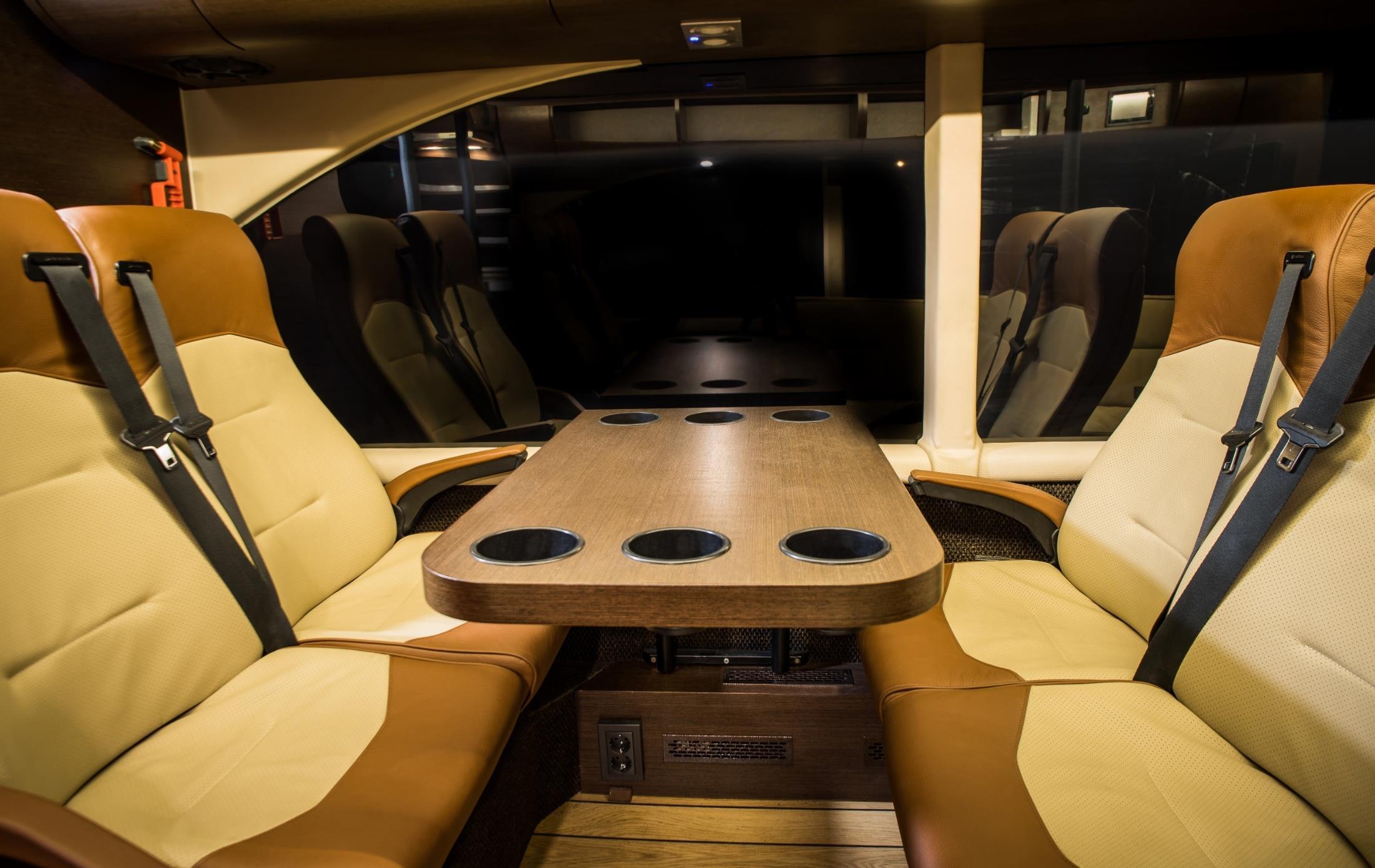 Lounge seating and table inside the HGK Motorsport team bus