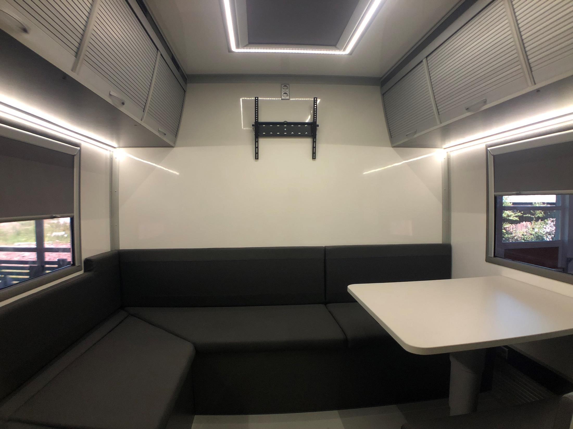 Lounge seating and table inside the MAN TGS transporter